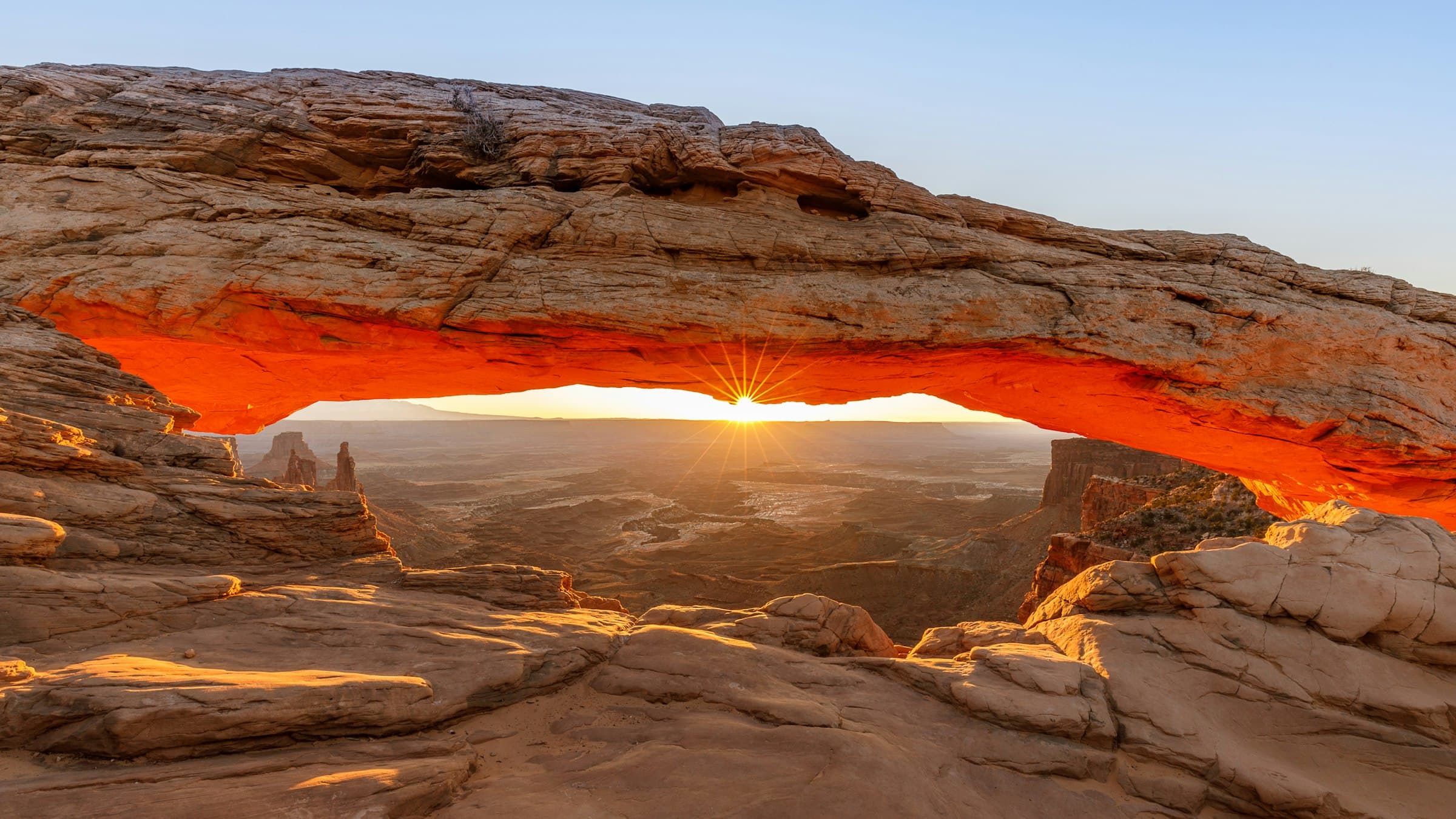 Mesa Arch glowing orange at sunrise, Canyonlands National Park, Utah